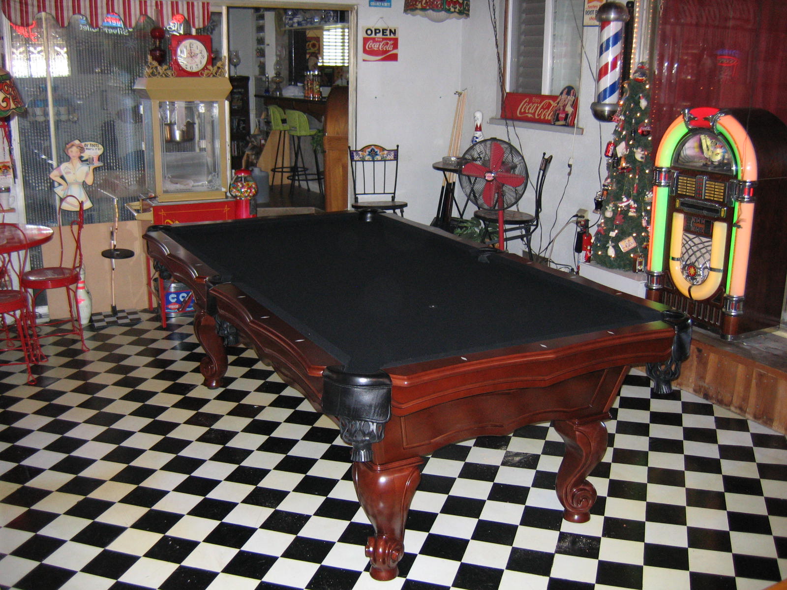 pool table with black felt in Coca Cola themed room